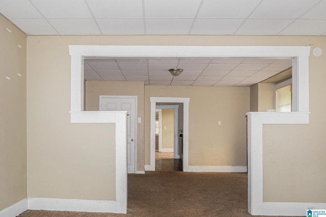 hallway with a drop ceiling and carpet