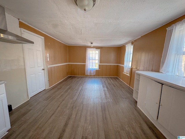 501 S Ledbetter St, Anniston, AL 36201 - unfurnished dining area featuring dark wood-type flooring, a textured ceiling, wooden walls, and wainscoting