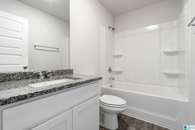 full bathroom with hardwood / wood-style flooring, toilet, vanity, and shower / washtub combination