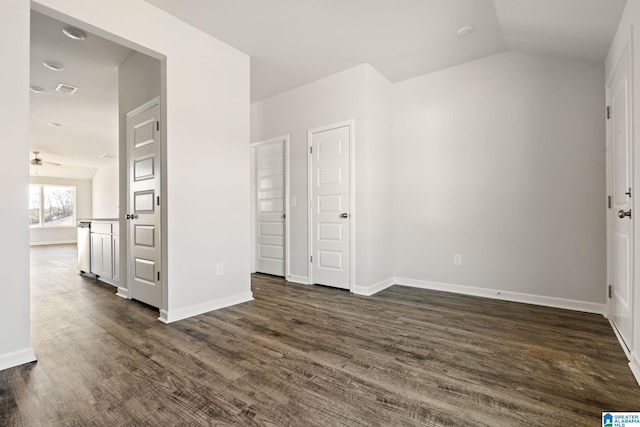 empty room with ceiling fan, dark hardwood / wood-style flooring, and lofted ceiling