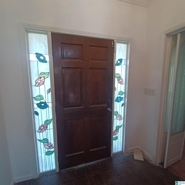 foyer featuring dark tile patterned flooring