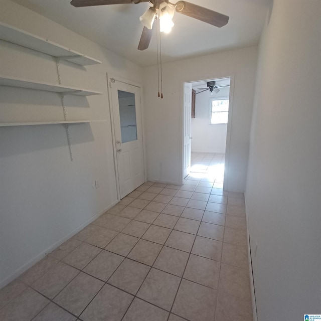 spare room with ceiling fan and light tile patterned flooring