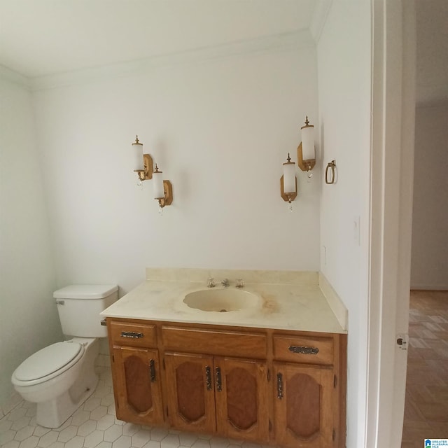 bathroom with toilet, vanity, tile patterned floors, and ornamental molding