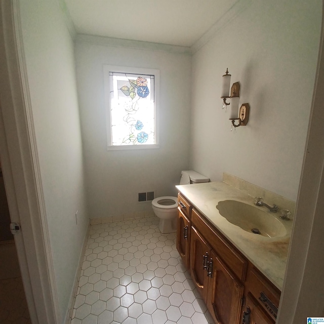 bathroom with tile patterned floors, vanity, toilet, and crown molding