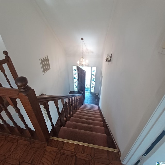 stairs with a towering ceiling and an inviting chandelier