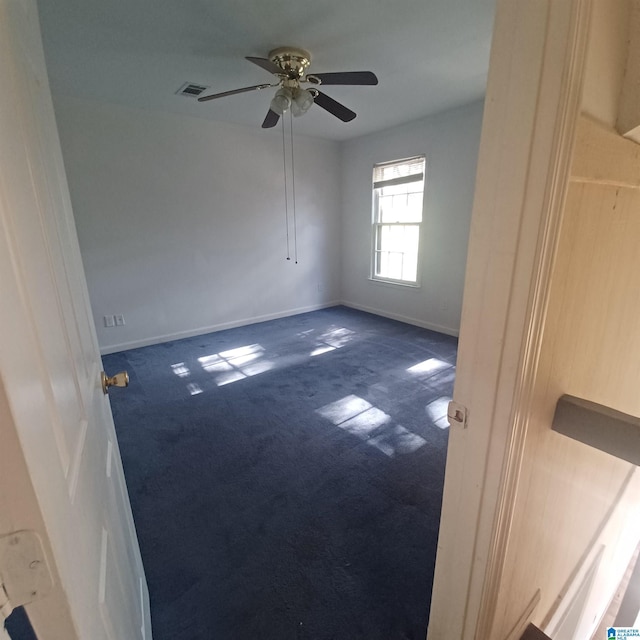 carpeted spare room with ceiling fan