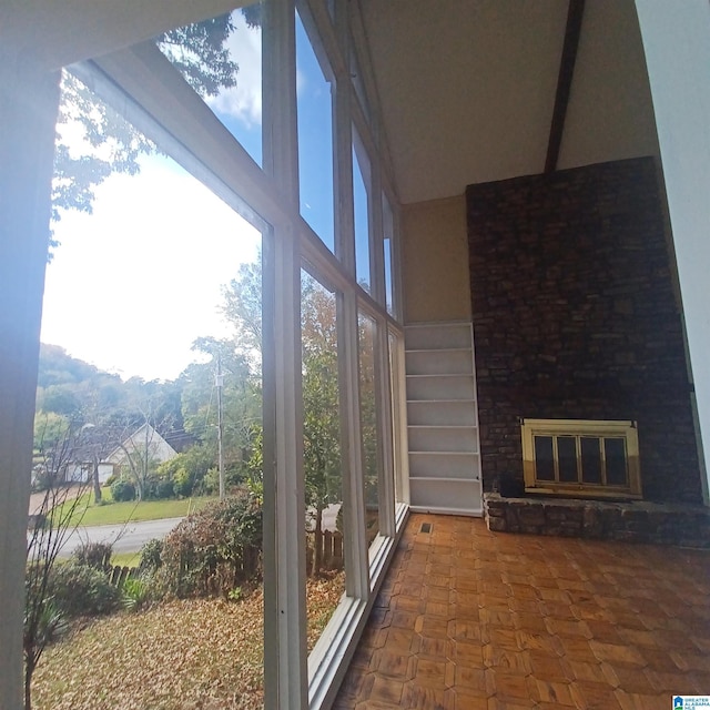 sunroom / solarium with a stone fireplace