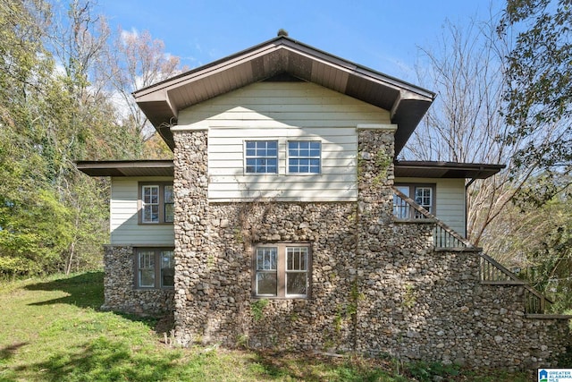 view of side of home with a yard