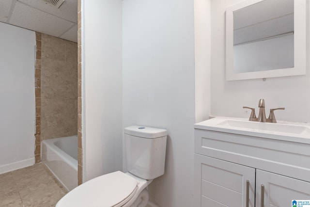 bathroom featuring a paneled ceiling, tile patterned flooring, vanity, and toilet