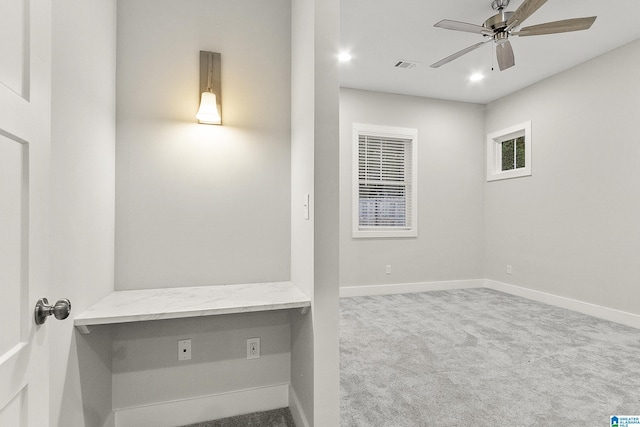 interior space featuring carpet, visible vents, built in desk, and baseboards