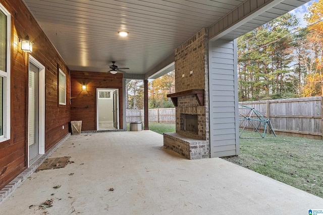 view of patio / terrace with ceiling fan, an outdoor brick fireplace, and a fenced backyard