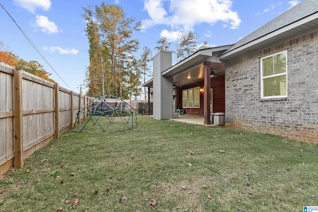 view of yard with a ceiling fan, a patio area, and a fenced backyard