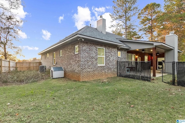 rear view of house featuring a fenced backyard, a chimney, a lawn, and a patio