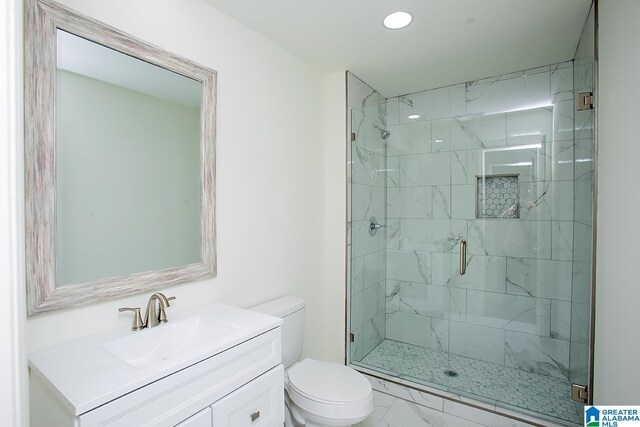 bathroom with vanity, toilet, and a shower with door