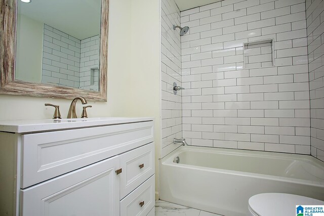 full bathroom with vanity, tiled shower / bath combo, and toilet