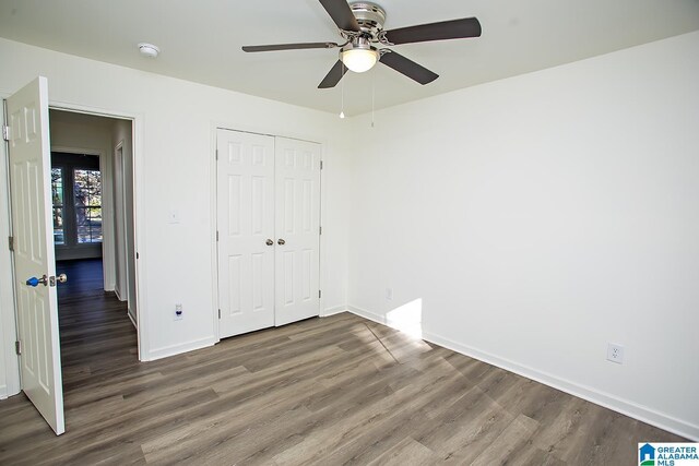 unfurnished bedroom featuring ceiling fan, a closet, and dark hardwood / wood-style floors