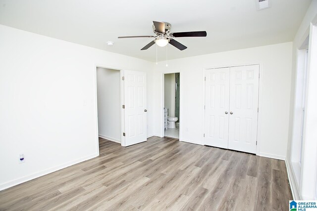 unfurnished bedroom with ceiling fan, light hardwood / wood-style floors, ensuite bathroom, and a closet