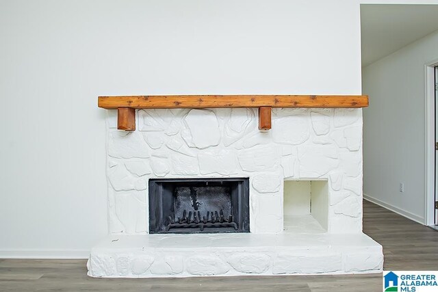 details featuring hardwood / wood-style floors and a stone fireplace