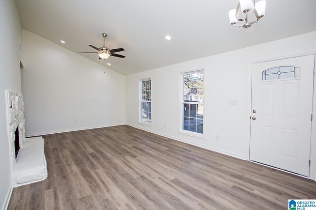 unfurnished living room featuring a fireplace, ceiling fan with notable chandelier, light hardwood / wood-style floors, and lofted ceiling