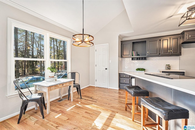 kitchen featuring black electric stovetop, backsplash, pendant lighting, light hardwood / wood-style floors, and lofted ceiling