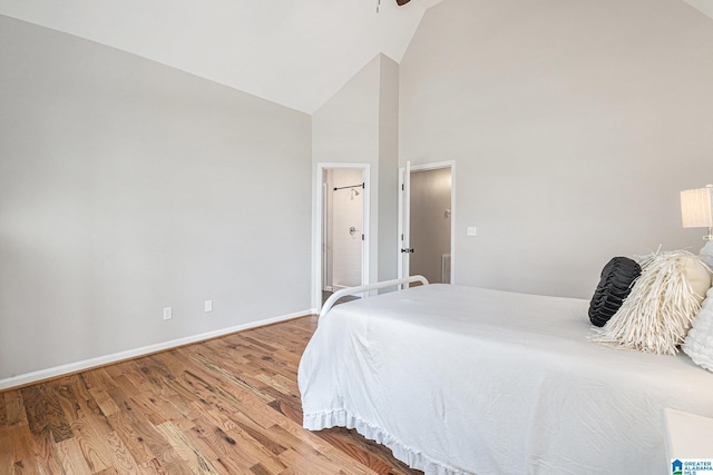 bedroom with hardwood / wood-style flooring and high vaulted ceiling