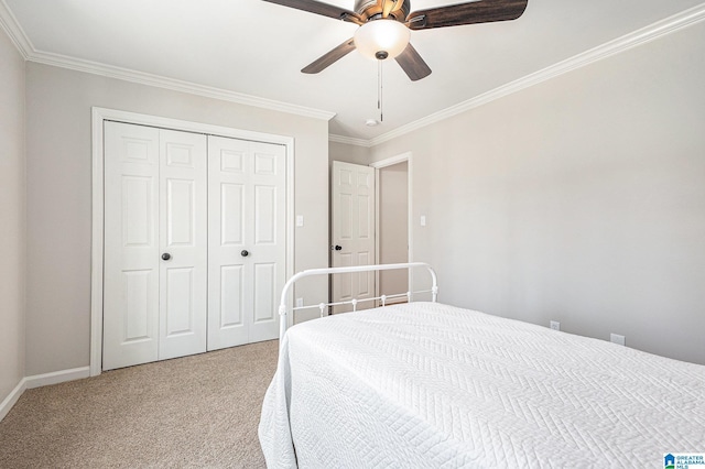 carpeted bedroom with a closet, ceiling fan, and crown molding