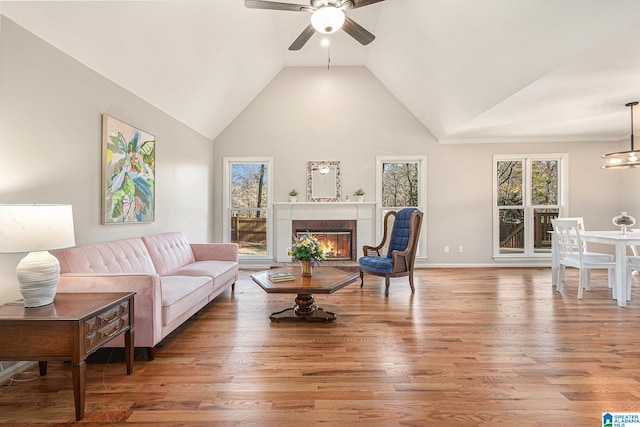 living room with hardwood / wood-style flooring, high vaulted ceiling, and ceiling fan