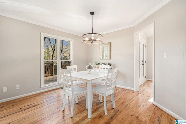 dining room featuring a chandelier, light hardwood / wood-style flooring, and crown molding