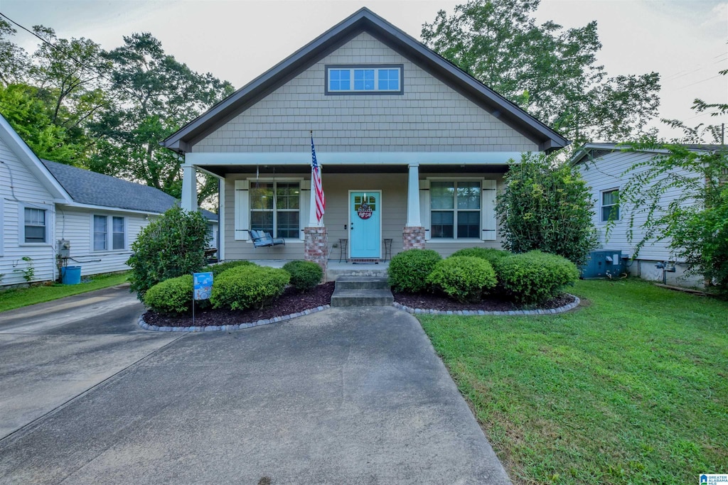 view of front of property featuring covered porch and a front yard