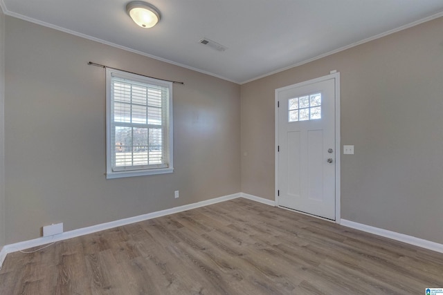 foyer featuring light hardwood / wood-style flooring, a healthy amount of sunlight, and crown molding