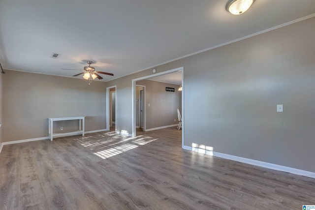 empty room featuring ceiling fan, light hardwood / wood-style flooring, and ornamental molding