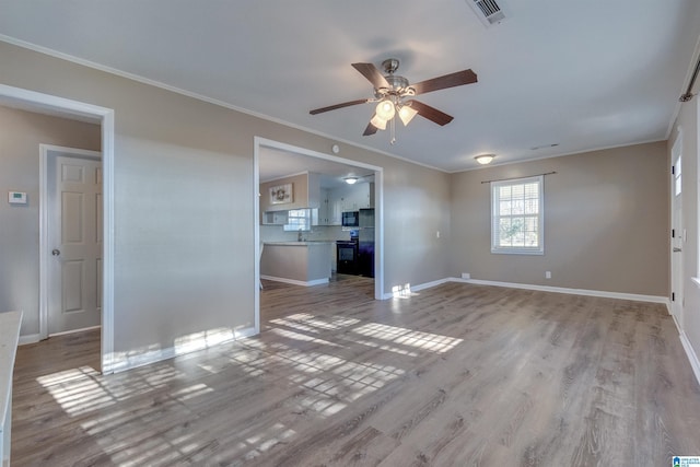 unfurnished living room featuring light wood-type flooring, ceiling fan, crown molding, and sink