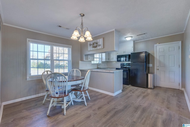 dining room with a notable chandelier, light wood-type flooring, and crown molding