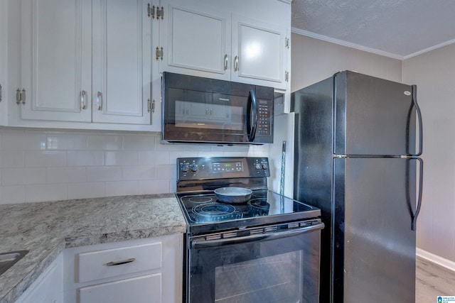 kitchen featuring black appliances, decorative backsplash, white cabinets, and light hardwood / wood-style flooring