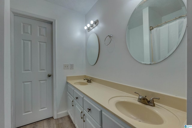 bathroom featuring vanity, a textured ceiling, and hardwood / wood-style flooring