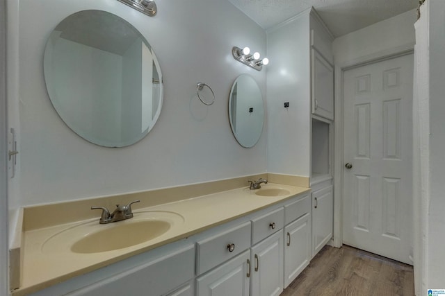 bathroom featuring vanity, wood-type flooring, and a textured ceiling