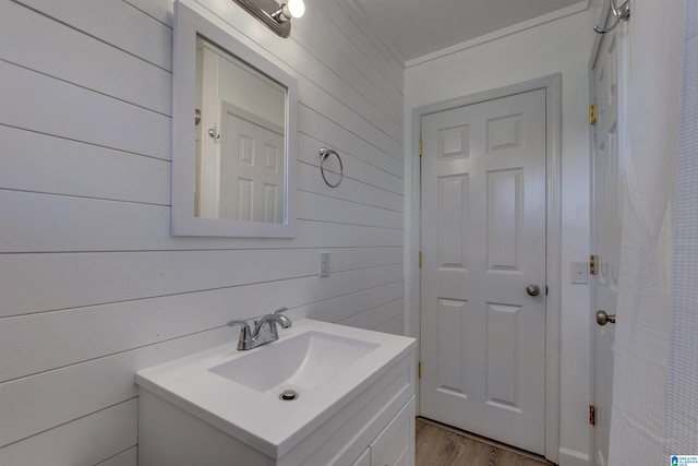 bathroom with vanity, wood walls, and wood-type flooring