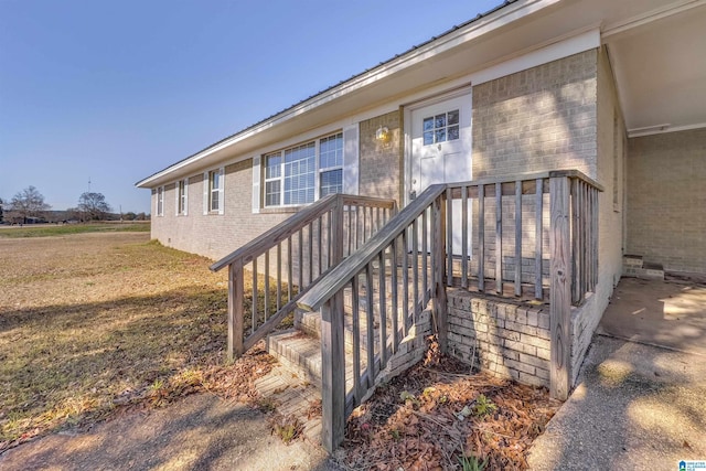 doorway to property featuring a lawn