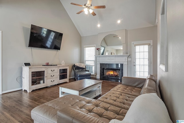 living room featuring ceiling fan, dark hardwood / wood-style flooring, a premium fireplace, and high vaulted ceiling