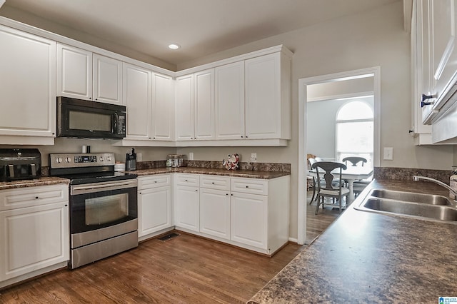 kitchen featuring electric range, dark hardwood / wood-style floors, white cabinetry, and sink