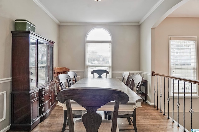 dining space featuring ornamental molding, light hardwood / wood-style floors, and a healthy amount of sunlight