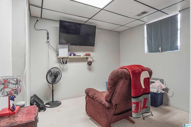 living area with carpet flooring and a paneled ceiling