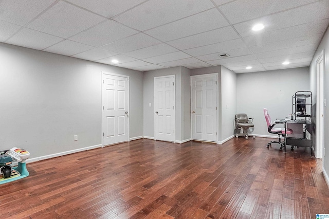 basement with dark hardwood / wood-style floors and a drop ceiling