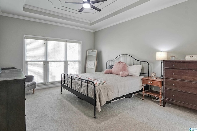 carpeted bedroom featuring a raised ceiling, ceiling fan, and crown molding