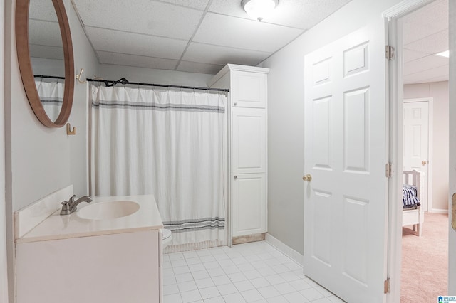 bathroom with a paneled ceiling, walk in shower, vanity, tile patterned flooring, and toilet