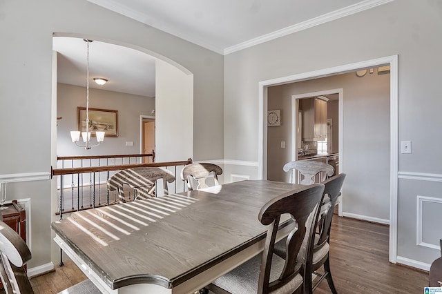 dining space with a notable chandelier, dark hardwood / wood-style floors, and ornamental molding