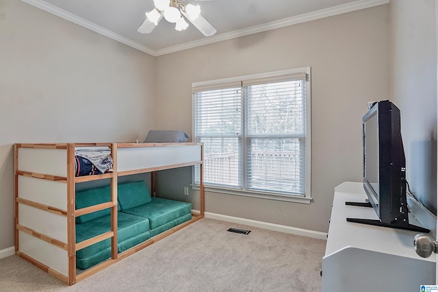 carpeted bedroom featuring ceiling fan and crown molding