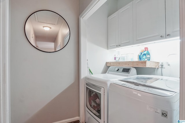 washroom with cabinets and washing machine and clothes dryer