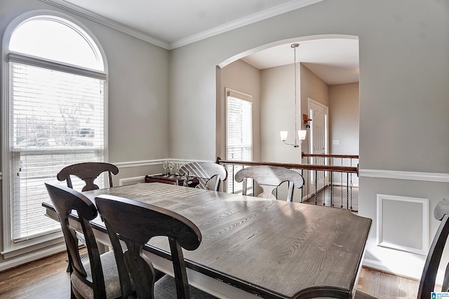 dining space featuring hardwood / wood-style floors, a notable chandelier, and crown molding