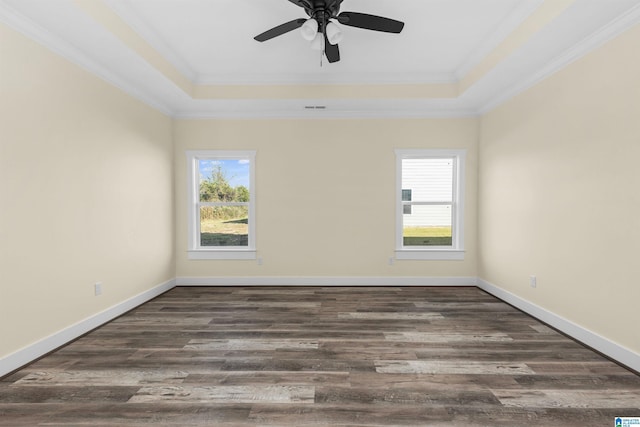 spare room featuring ceiling fan, ornamental molding, dark wood-type flooring, and a tray ceiling